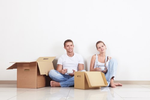 Professional movers carrying furniture from a Kilburn flat