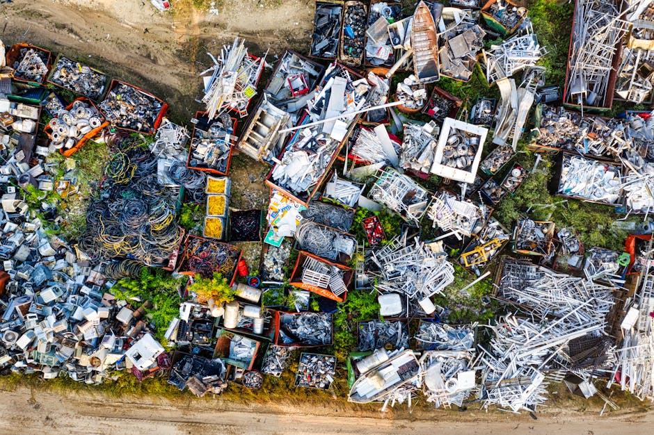 A large pile of black plastic garbage bags filled with waste, situated outdoors next to a modern building with tiled walls. Some of the bags are partially open, revealing discarded plastic bottles and